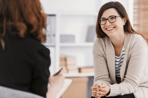 Woman smiles while talking to therapist in bipolar disorder treatment program