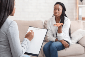 Woman talks to therapist after entering process addiction treatment 