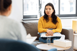 Woman sits on couch and listens to therapist about a new personality disorder treatment program