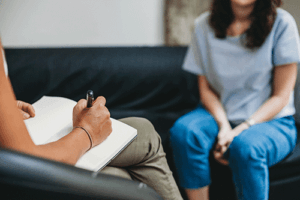 Therapist takes note about new client as she enters women's residential treatment 