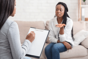 Woman sits on couch and talks to therapist about referring professionals resources 