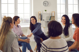 Women gather in alcohol addiction and rehab treatment to discuss setting boundaries in recovery.