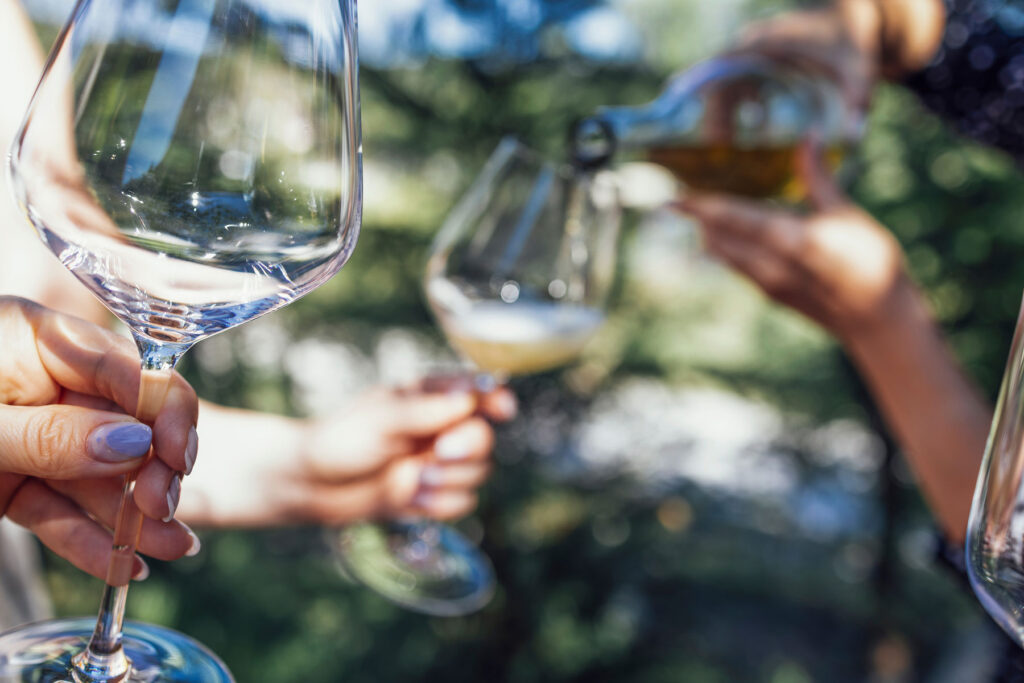 Women hold up wine glasses to represent binge drinking