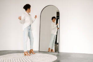 Woman with body image issues checks herself out in mirror