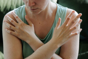 a woman taps her shoulders during EMDR therapy